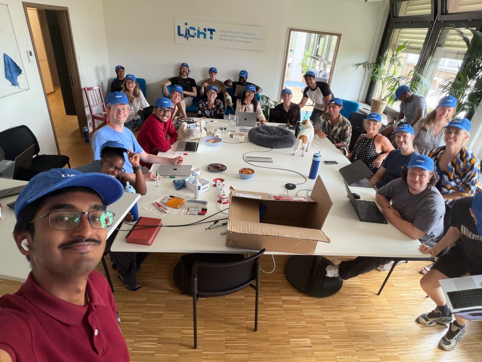 The lab around one long table, everyone in blue LiGHT caps