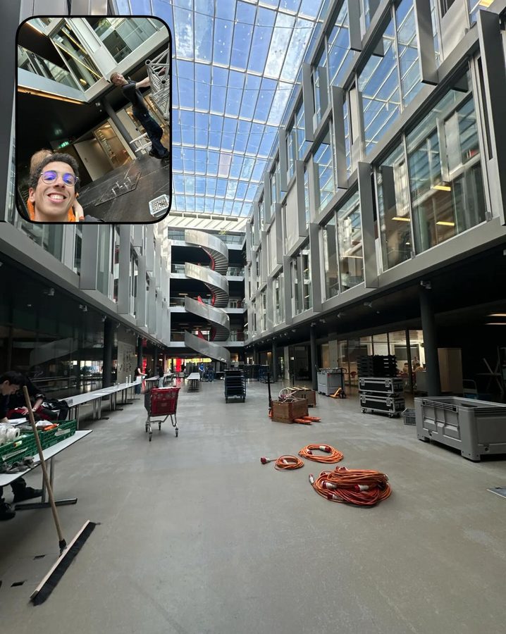 An empty glass-roofed atrium with coiled cables and trolleys on the floor; an inset shows a student pulling a face at the camera.