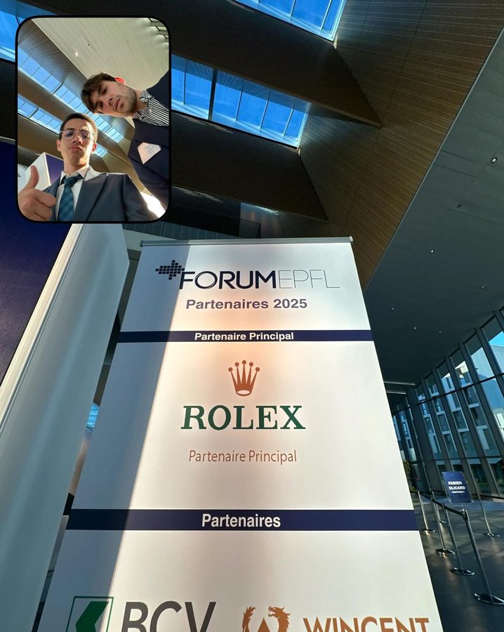 A tall Forum EPFL board listing the 2025 partners, seen from below; an inset shows two students in suits.
