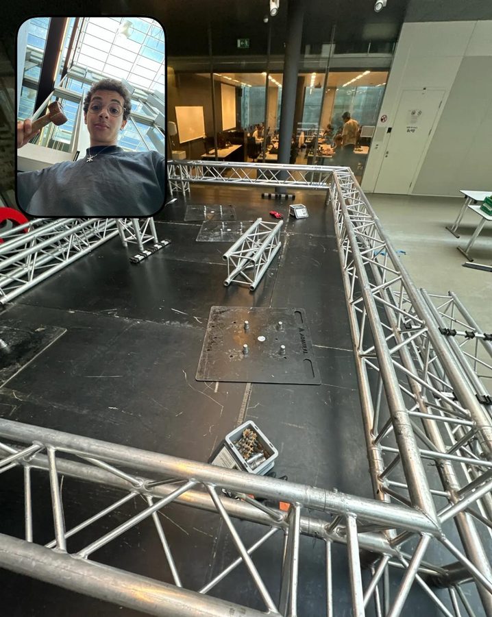 Aluminium truss pieces laid out on a black stage floor; an inset shows a student waving.